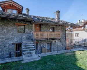 une maison en pierre avec une véranda et une terrasse dans l'établissement Chalet vista Monte Bianco, à La Salle