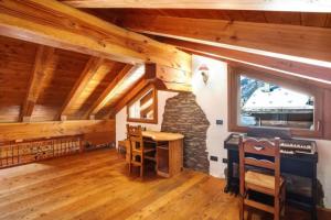 a room with a stone fireplace and a table and chairs at Chalet vista Monte Bianco in La Salle