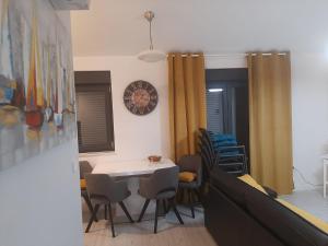 a dining room with a table and chairs and a clock at Apartments Šućur in Preko