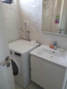a bathroom with a washing machine and a sink at Apartments Šućur in Preko