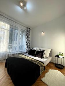 a bedroom with a bed with black and white pillows at Cracow Heart Apartment in Krakow