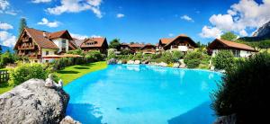 a large swimming pool in a yard with houses at Bio-Bauernhof Simonbauer in Ramsau am Dachstein