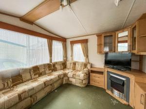 a living room with a couch and a flat screen tv at 6 Berth Dog Friendly Caravan In Hunstanton In Norfolk Ref 13014l in Hunstanton