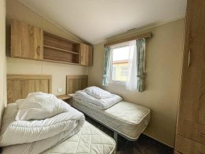 two beds in a small room with a window at Great Caravan For Hire By The Beach In Norfolk, By Hunstanton Beach Ref 13005l in Hunstanton