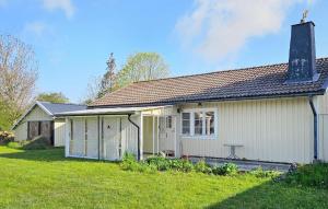 a small white house with a grass yard at Beautiful Home In Borgholm With 2 Bedrooms in Föra