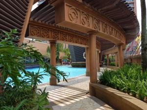 a wooden pergola next to a swimming pool at RN Service Suites At Times Square KL in Kuala Lumpur