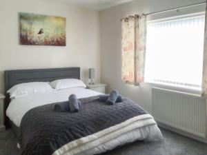 a bedroom with a bed with two stuffed animals on it at Moor Close in Alne