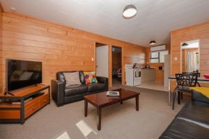 ein Wohnzimmer mit einem Sofa und einem TV in der Unterkunft Hanmer Springs TOP 10 Holiday Park in Hanmer Springs