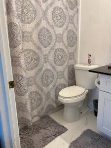 a bathroom with a toilet and a shower curtain at The Orchid Townhouse! 2B/2.5B in Miami Gardens