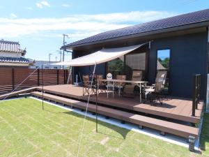 una terraza con una mesa y una sombrilla blanca en Awajishima Cottage Hitotoki - Vacation STAY 10755v, en Sumoto