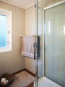 a bathroom with a shower with a glass door at Spacious villa with view - 5BR - FREE parking - Great Wi-Fi in Bergen +30 photos