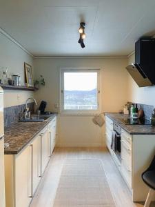 a large kitchen with a sink and a window at Villa with incredible view, 5 BR in Bergen