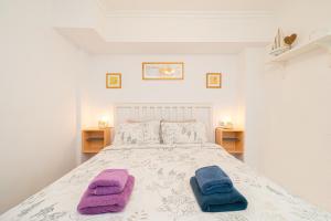 sypialnia z łóżkiem i dwoma ręcznikami na nim w obiekcie Casita del Puerto 1 w mieście Santa Pola