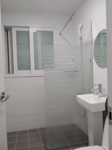 龜尾的住宿－Ekonomy Hotel，带淋浴和盥洗盆的白色浴室