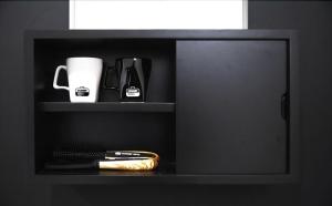 a shelf with a cupboard with a keyboard and cups at Ekonomy Hotel in Gumi