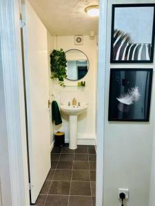 baño con lavabo, espejo y lavabo blanco en Delightful 1-bed Apt with Free Parking and Wi-fi by HP Accommodation, en Milton Keynes