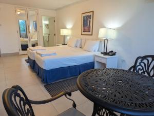 um quarto de hotel com uma cama, uma mesa e cadeiras em Pirate's Inn em Bridgetown