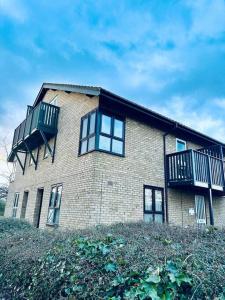 a brick building with a balcony on top of a hill at Delightful 1-bed Apt with Free Parking and Wi-fi by HP Accommodation in Milton Keynes