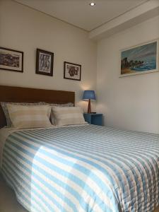 Schlafzimmer mit einem Bett mit einer blauen und weißen Bettdecke in der Unterkunft SBT Sun Beach Terrace "The best house" in Figueira da Foz