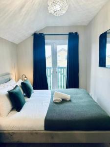 a bedroom with a large bed with blue curtains at Delightful 1-bed Apt with Free Parking and Wi-fi by HP Accommodation in Milton Keynes