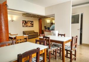 a restaurant with tables and chairs and a couch at GS Hotel in Salta