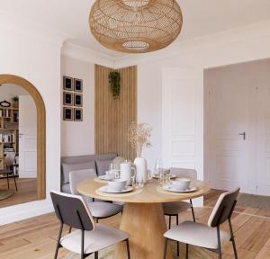 uma sala de jantar com uma mesa de madeira e cadeiras em Appartement de luxe à côté du stade de France - JO 2024- Et avec accès à Paris en 10 mn em Enghien-les-Bains