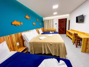 a hotel room with two beds and a desk at Pousada Villa Marceneiro Beach in Passo de Camarajibe +46 photos