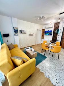 Rio Apart Deluxe في صوفيا: غرفة معيشة مع أريكة صفراء وطاولة