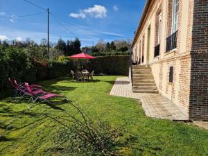 un patio con mesa, sillas y sombrilla en Les Fougères en Honfleur