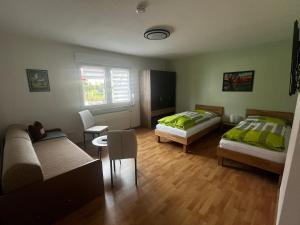 sala de estar con 2 camas y sofá en Ferienwohnung Schneider, en Baumholder