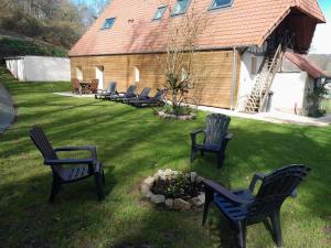 a yard with chairs and a flower bed and a building at Maison de 3 chambres avec jardin clos et wifi a Offranville a 4 km de la plage in Offranville