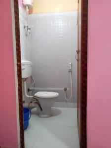 a bathroom with a toilet and a shower at The Orchid Inn in Kolkata
