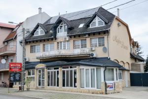 een gebouw op de hoek van een straat bij Major Panzió és Étterem in Hajdúszoboszló