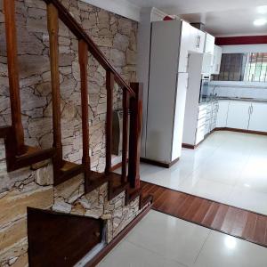 salon ze schodami i kamienną ścianą w obiekcie Chalet de ladrillos y tejas w mieście La Plata