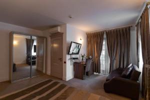 uma sala de estar com um sofá e um espelho em Deniz İnn Hotel em Baku