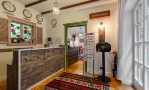 a room with a reception desk and a clock on the wall at Deniz İnn Hotel in Baku