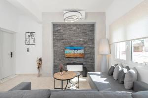 a living room with a couch and a brick wall at Casa di Hari in Afantou
