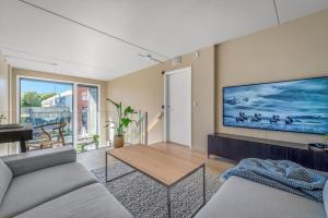 uma sala de estar com uma grande televisão na parede em Beautifull apartment w 1 bedroom em Oslo