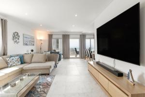ein Wohnzimmer mit einem großen Flachbild-TV in der Unterkunft Oceanview Dreamer's Delight in Nazaré