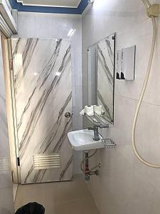 La salle de bains est pourvue d'un lavabo et d'une douche. dans l'établissement RS Galaxy HOTEL, à Phnom Penh