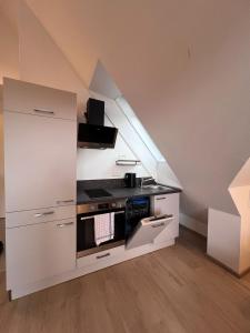 a white kitchen with a stove and a staircase at Ort 245 in Ried im Innkreis