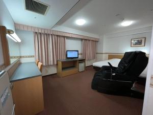 Pokój hotelowy z łóżkiem i biurkiem w obiekcie Hotel Alpha-One Marugame w mieście Marugame