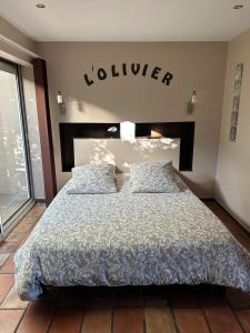 a bedroom with a large bed with alier sign on the wall at La Chambre de l'Olivier in Champigny-sur-Marne
