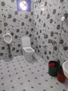baño con aseo, lavabo y urinario en Hotel Paradise, en Mandarmani