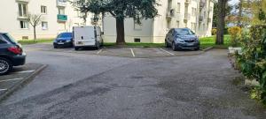 drie auto's geparkeerd op een parkeerplaats naast een gebouw bij Le petit chic in Vaucresson