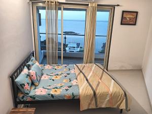 a bedroom with a bed with a view of the ocean at 2 BHK SKY water Apartment(SKY 2) in Marmagao