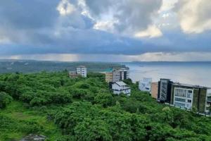 a group of buildings on a hill near the ocean at 2 BHK SKY water Apartment(SKY 2) in Marmagao
