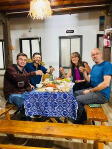 eine Gruppe von Menschen, die um einen Tisch sitzen in der Unterkunft Homestay Chinh Bi in Yên Bái
