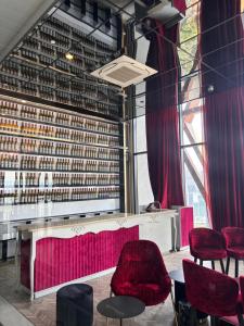 a room with red chairs and a table and a wall of wine bottles at Scarletz Comfy Suites KLCC by MOMO in Kuala Lumpur