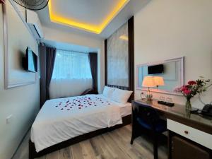 a bedroom with a bed and a desk with a computer at Hanoian Hotel in Hà Ðông